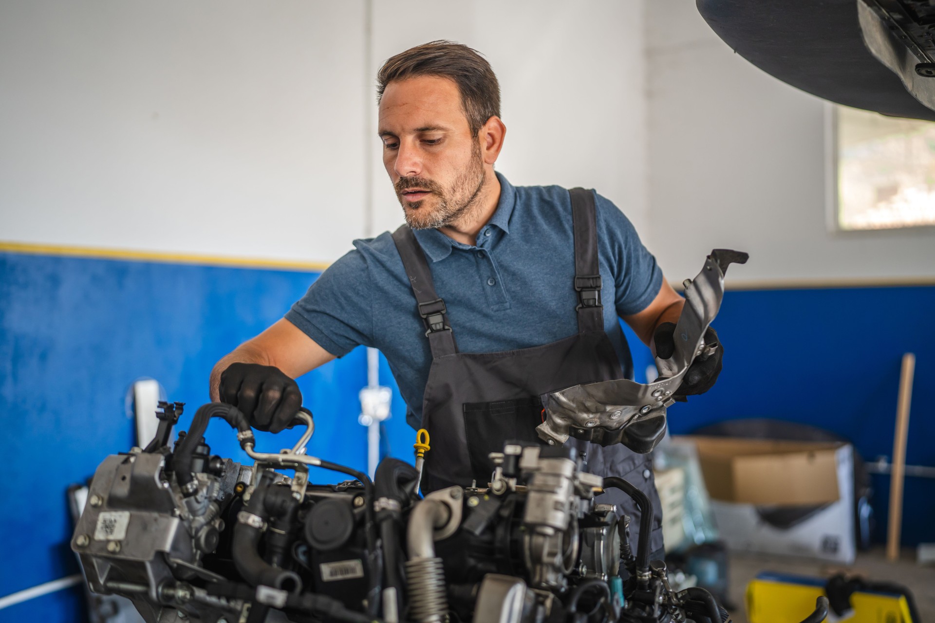 Car mechanic work on a car engine in an auto repair workshop